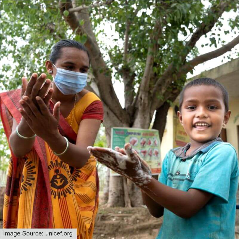 Boys being taught to sanitize hands