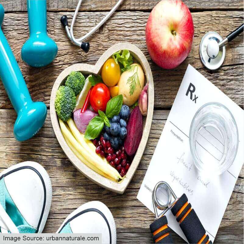 A healthy lifestyle is demonstrated by fruits, salads, and dumbbells
